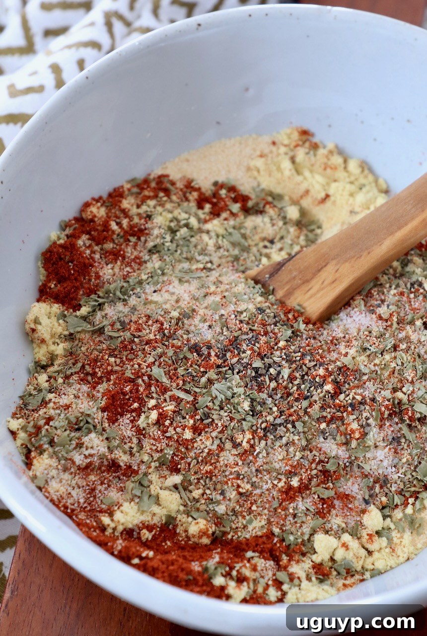 herbs and spices mixed together in bowl with wooden spoon