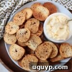 Bagel chips on plate with small bowl of cheese spread