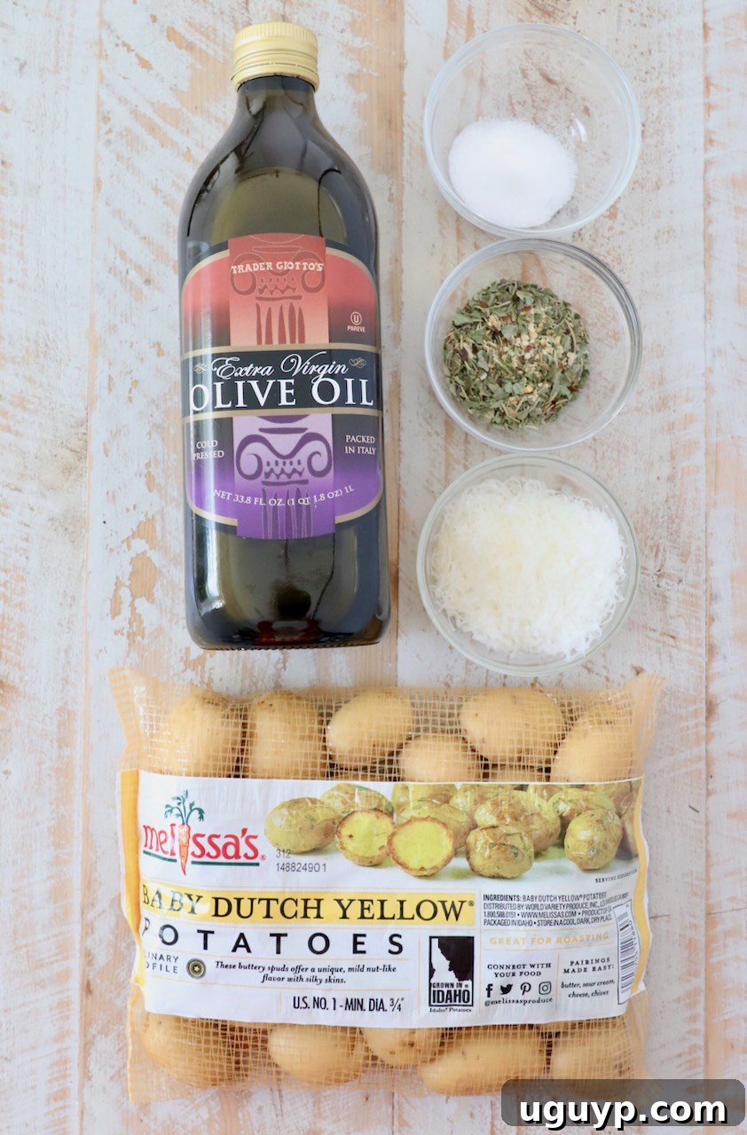 Ingredients for making roasted baby potatoes laid out on a white wooden board.