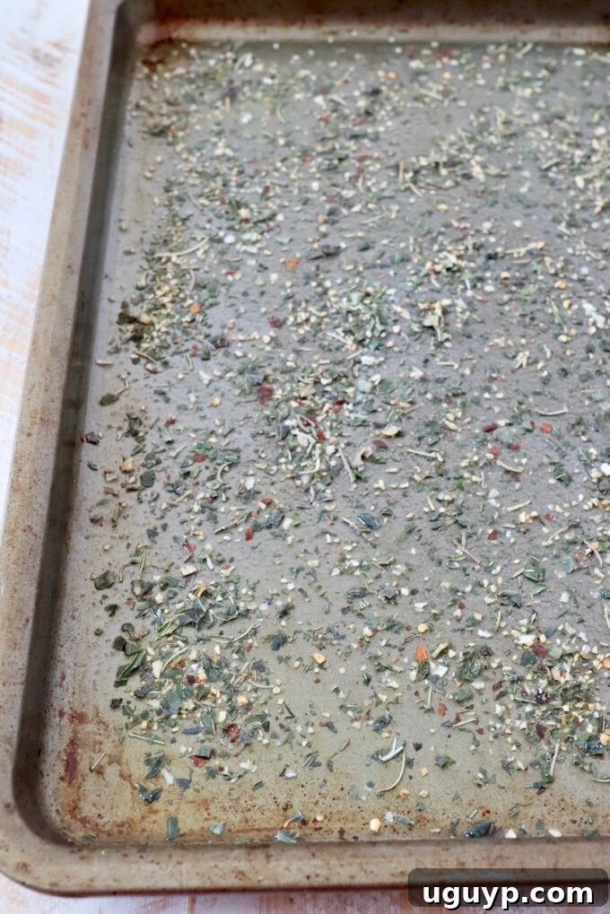 Italian seasoning evenly sprinkled on an olive oil coated baking sheet.