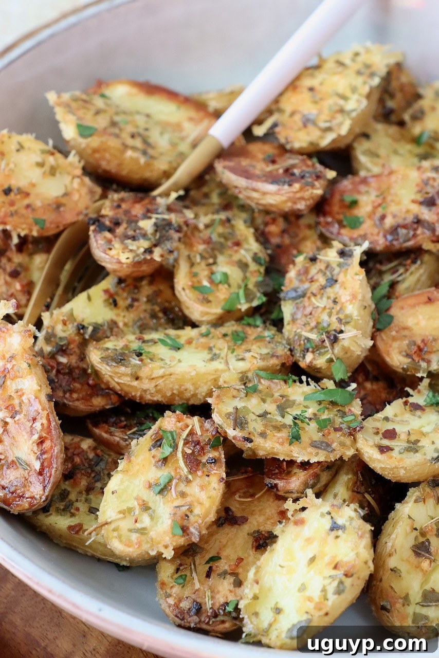 A generous serving of roasted baby potatoes in a rustic bowl, with a fork digging in.