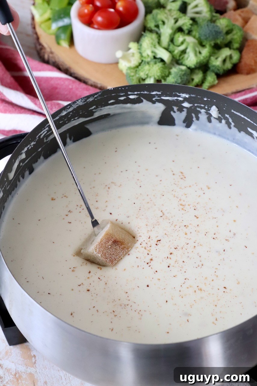piece of bread dipped into cheese fondue in fondue pot