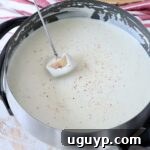 piece of bread dipped into cheese fondue in pot