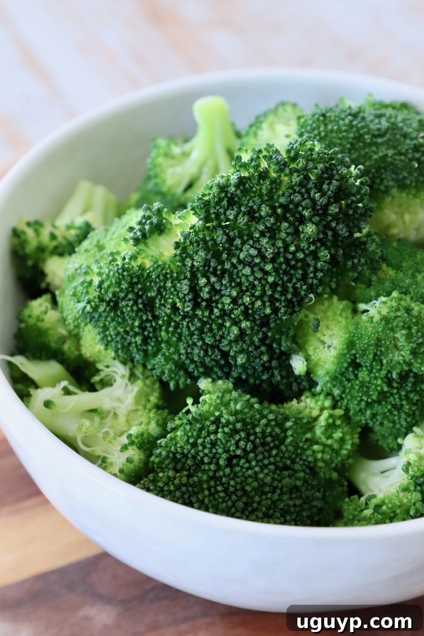 Steamed broccoli florets in a white bowl, ready to serve.