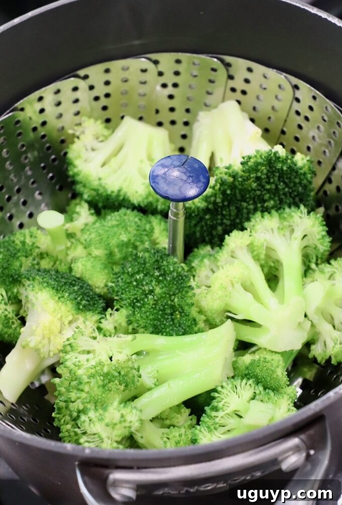 Steamed broccoli perfectly cooked in a steamer basket inside a pot.