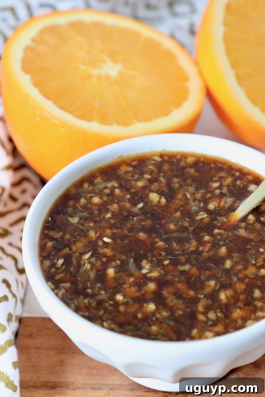 A small bowl of vibrant orange sauce with a spoon, ready to be served or used.