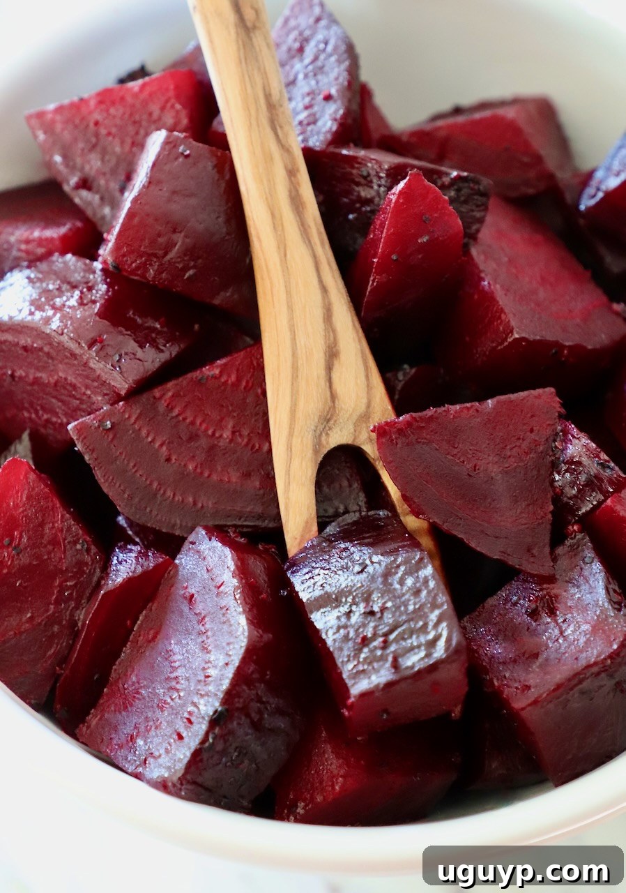 cooked diced beets in bowl with wooden fork