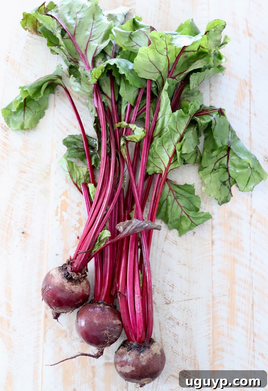 Freshly harvested beets with their vibrant green tops, ready for preparation.