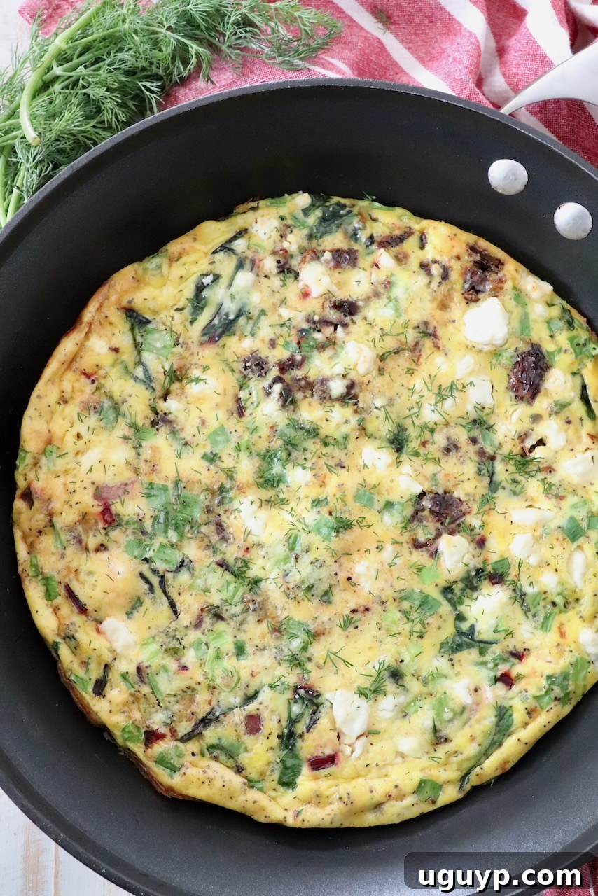 A perfectly cooked frittata, golden brown and set, garnished and ready to be sliced directly from the skillet.