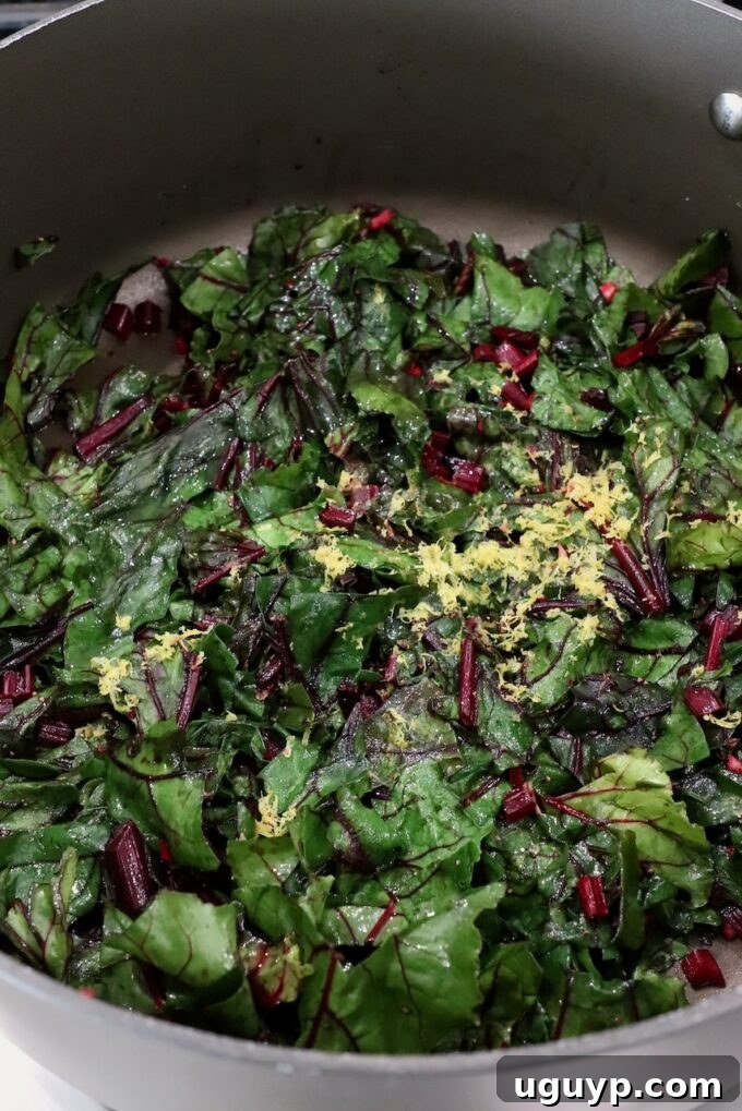 Sautéed beet greens, perfectly wilted and seasoned, ready to be served from a large pot.