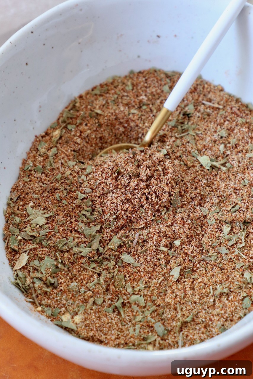 A bowl filled with homemade Southwest seasoning, accompanied by a small spoon, ready for culinary use.