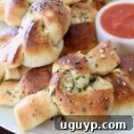 garlic knots on plate with small bowl of marinara sauce