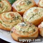 Baked pickle rolls on a plate, garnished with fresh dill.