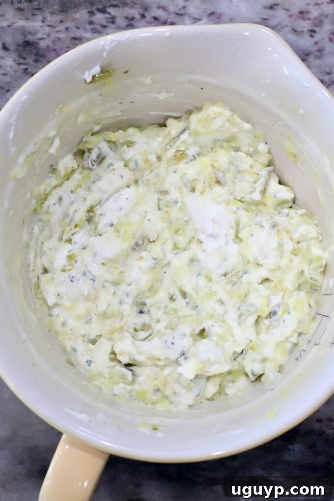 Softened cream cheese, ranch seasoning, and dill pickle relish combined in a mixing bowl, ready to be stirred.