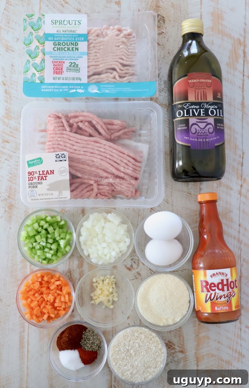 All the essential ingredients for making homemade buffalo chicken meatballs, including ground meats, vegetables, spices, and sauces, neatly arranged on a rustic white wooden board.