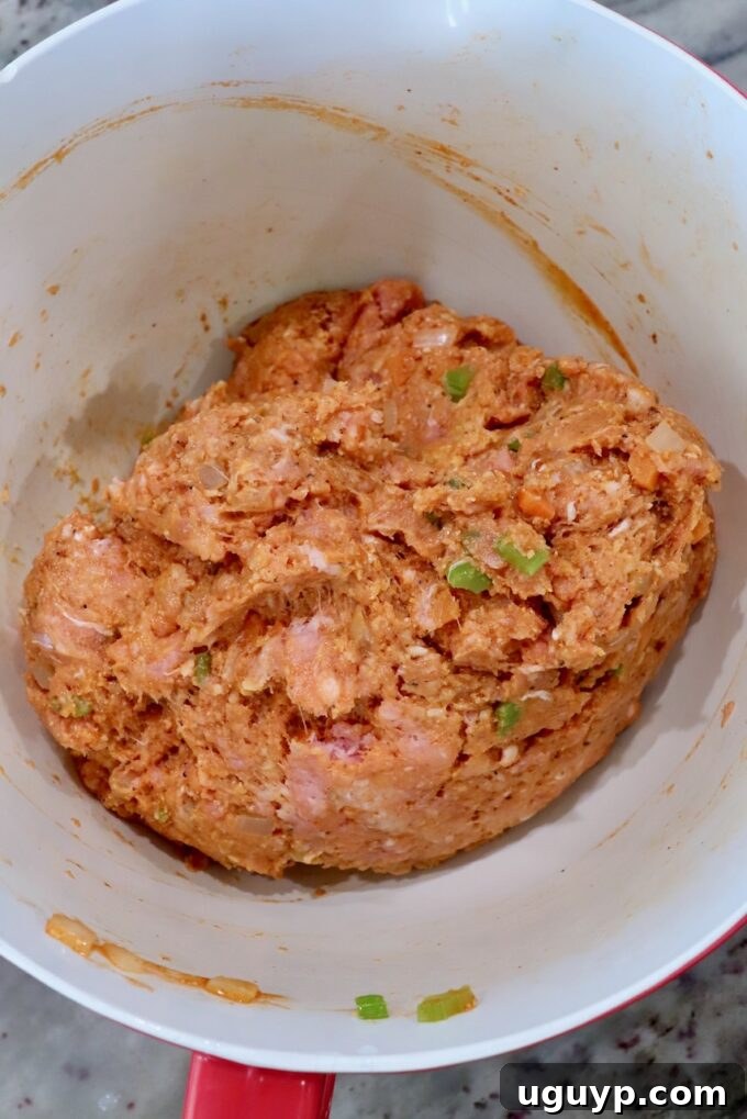 The raw buffalo chicken meatball mixture, perfectly combined and ready for forming, rests in a large bowl.