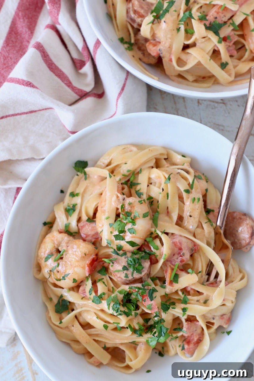 Overhead image of Cajun Shrimp Pasta in white bowls with fork
