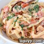 Cajun shrimp and sausage pasta in bowl with fork