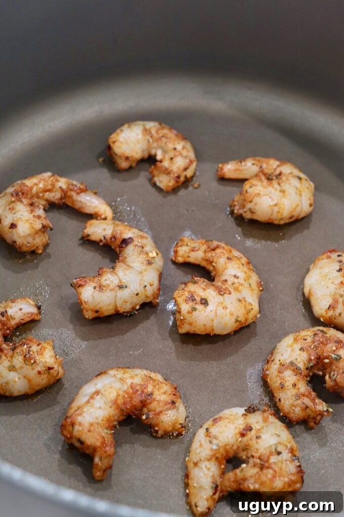 Seasoned shrimp cooking in a pan