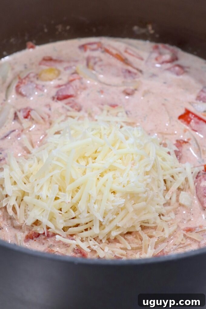 Shredded Parmesan cheese melting into the sauce in a pan