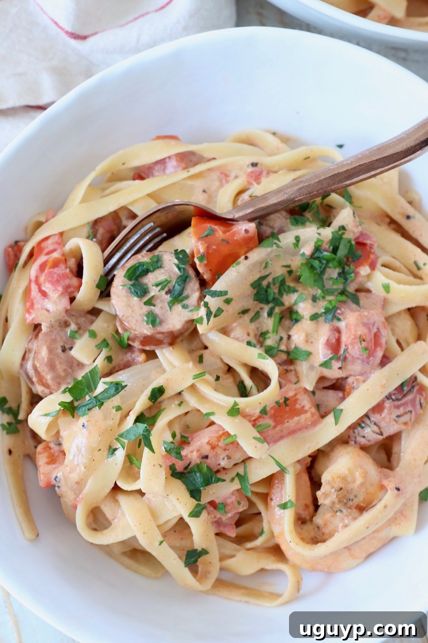 Cooked Cajun Shrimp Pasta with sausage in a bowl with a spoon