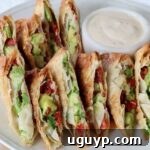 Avocado egg rolls sliced in half on a plate, ready to be served.