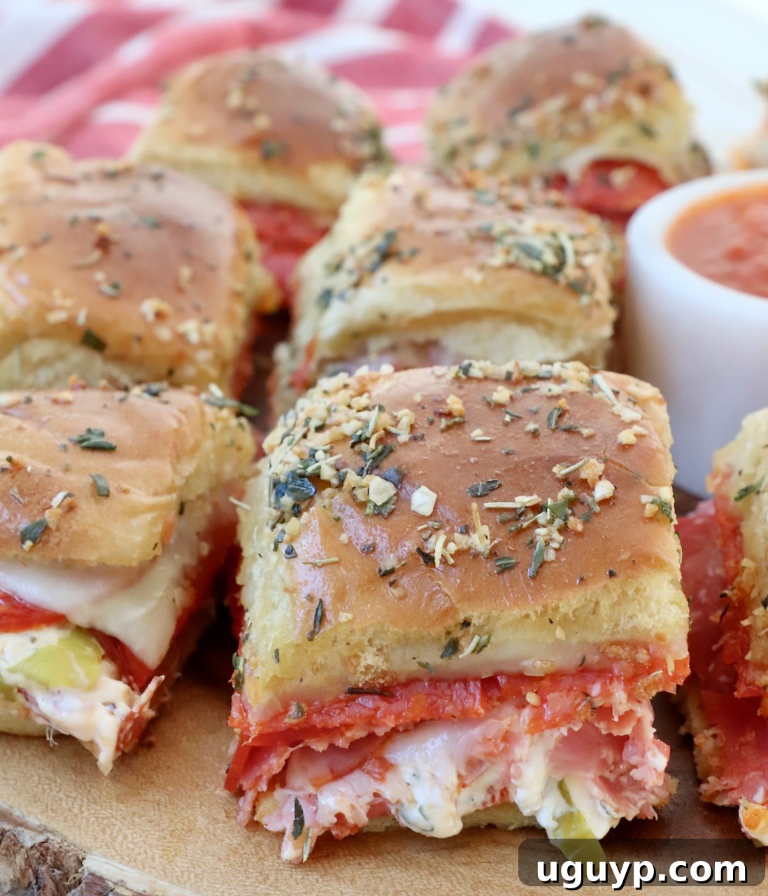 Hot Italian Sliders arranged on a wooden serving tray