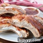 Cooked pork ribs on a plate, beautifully brushed with BBQ sauce, ready to be enjoyed.