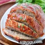 A succulent slice of Crock Pot Meatloaf, glistening with its savory glaze, ready to be enjoyed.