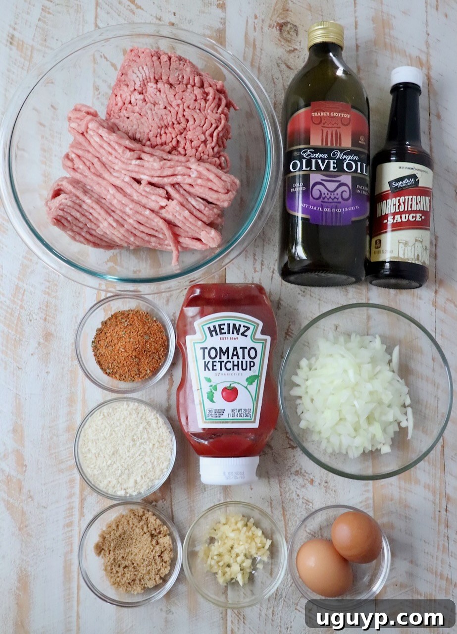 Fresh ingredients for Crock Pot Meatloaf laid out on a white wooden board, including ground meats, onions, garlic, and seasoning.