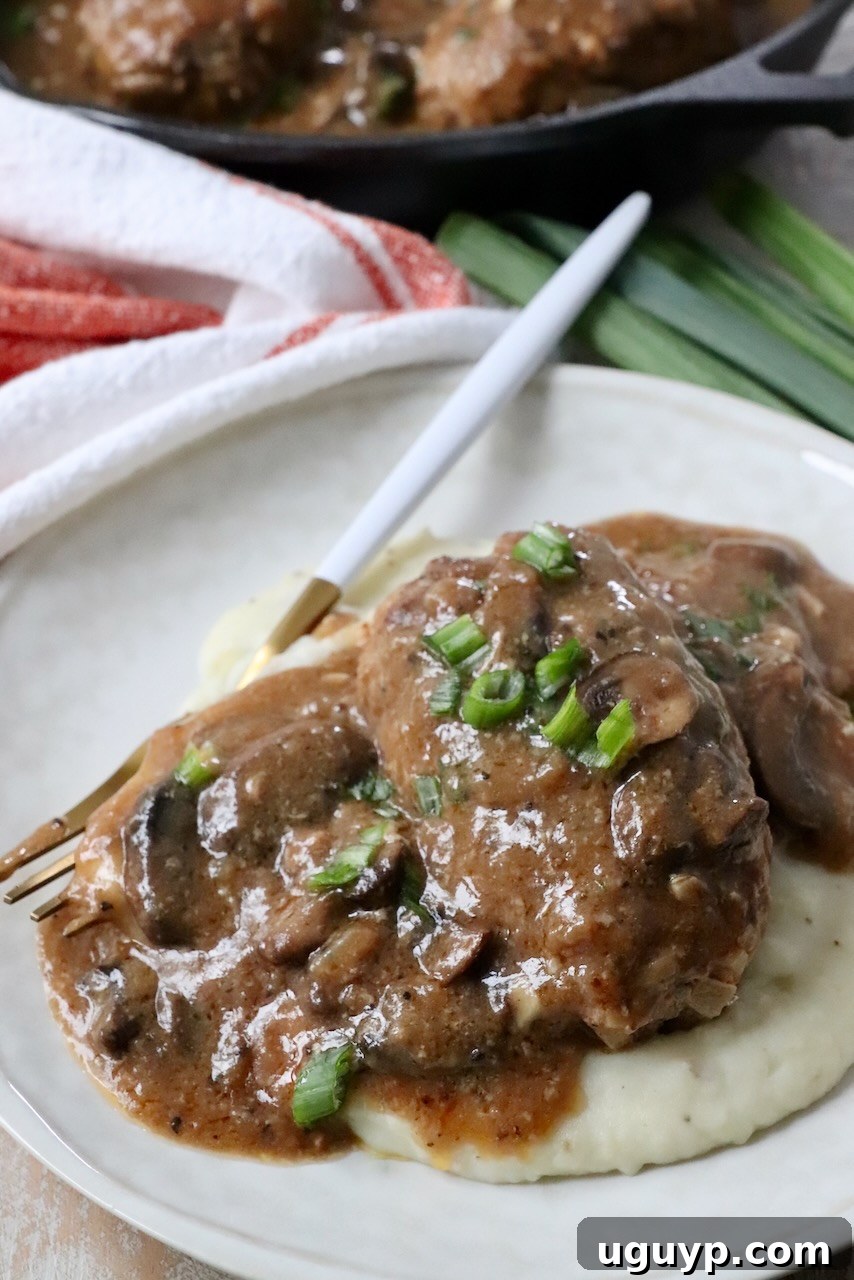 salisbury steak on plate with mushroom gravy and mashed potatoes