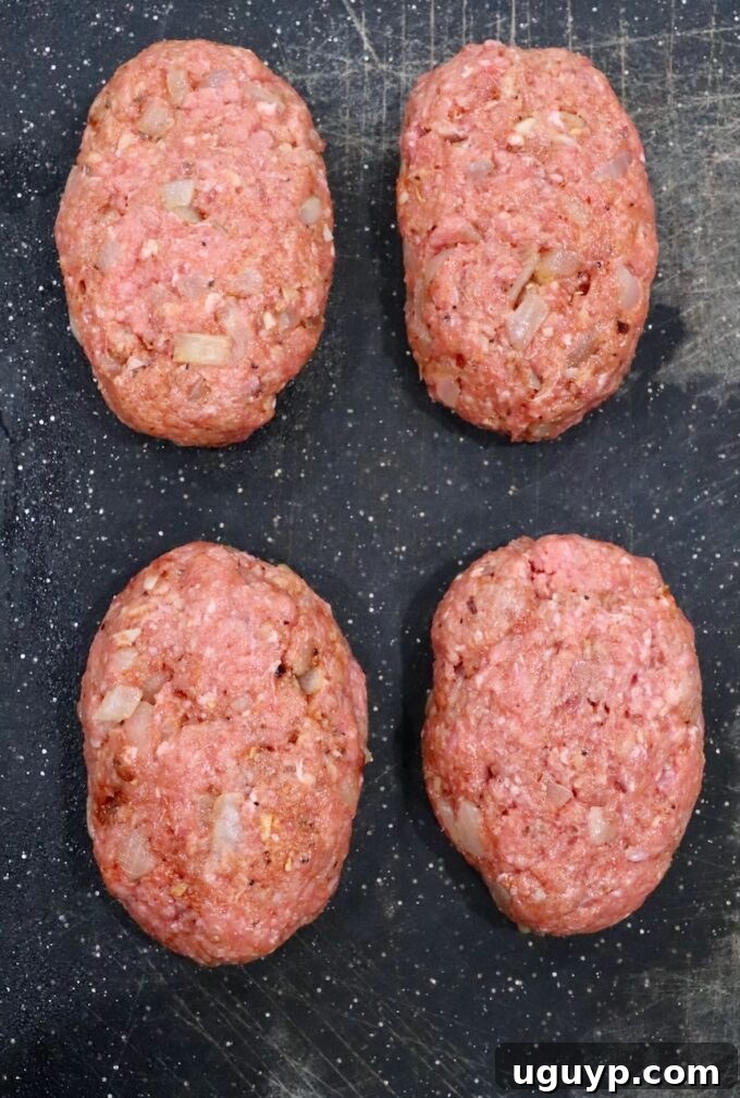 four beef patties on cutting board