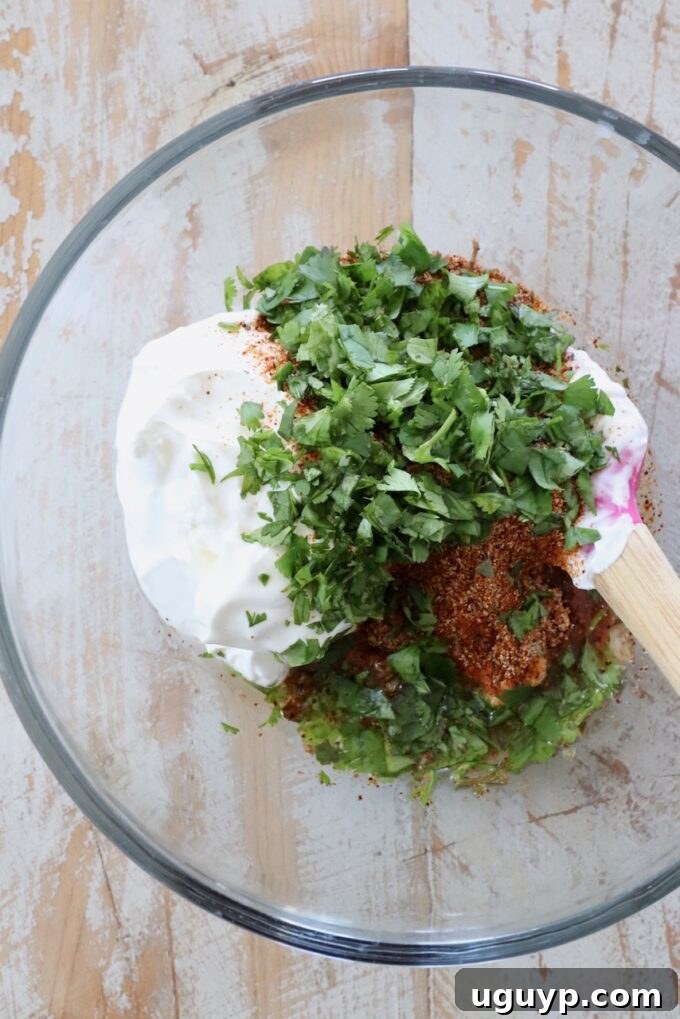 Individual ingredients like sour cream, cilantro, and various spices arranged in small glass bowls, highlighting their freshness.