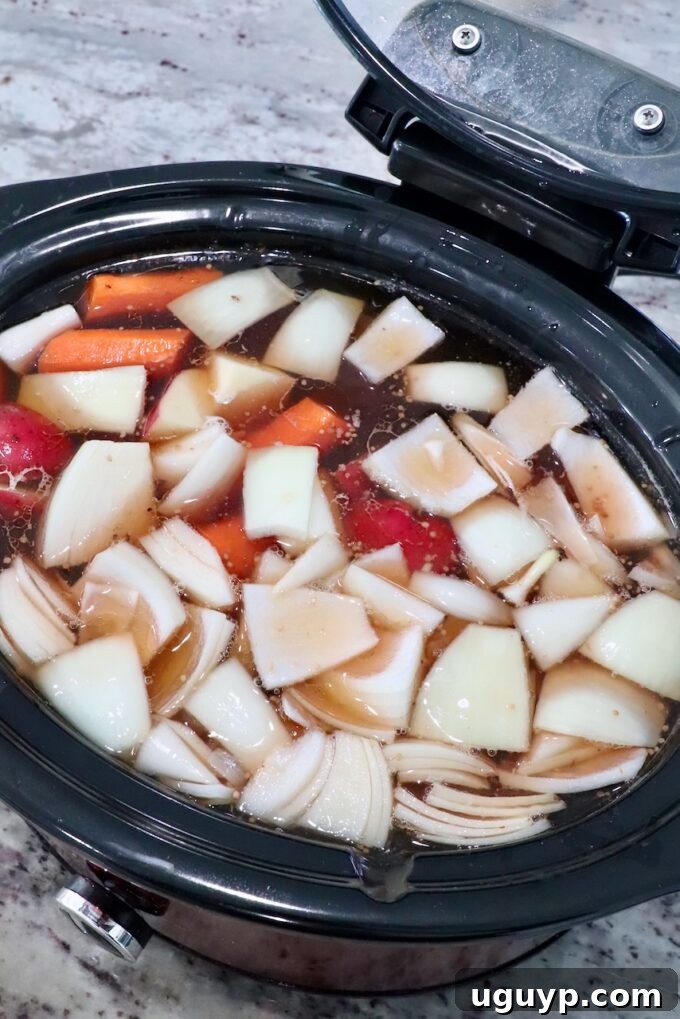 vegetables in crock pot with beef broth and brisket
