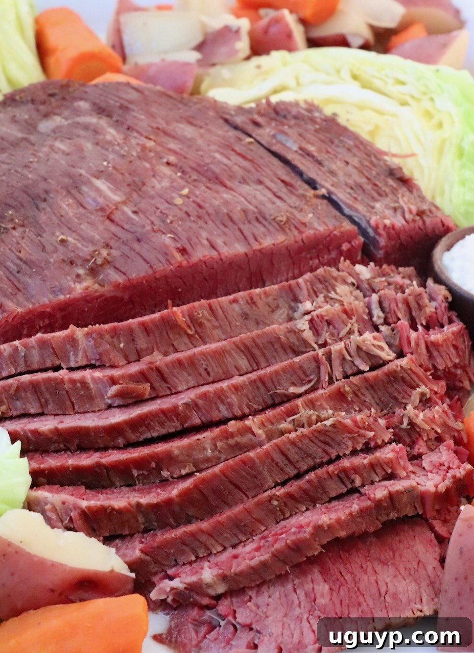 sliced corned beef on platter with cabbage and carrots