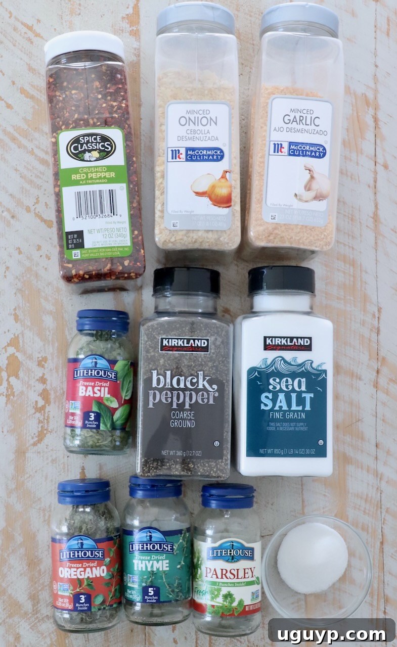 Individual herbs and spices arranged neatly in clear plastic containers on a white wooden surface, ready for blending.