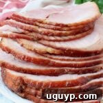 slices of ham stacked up on plate with a shiny glaze