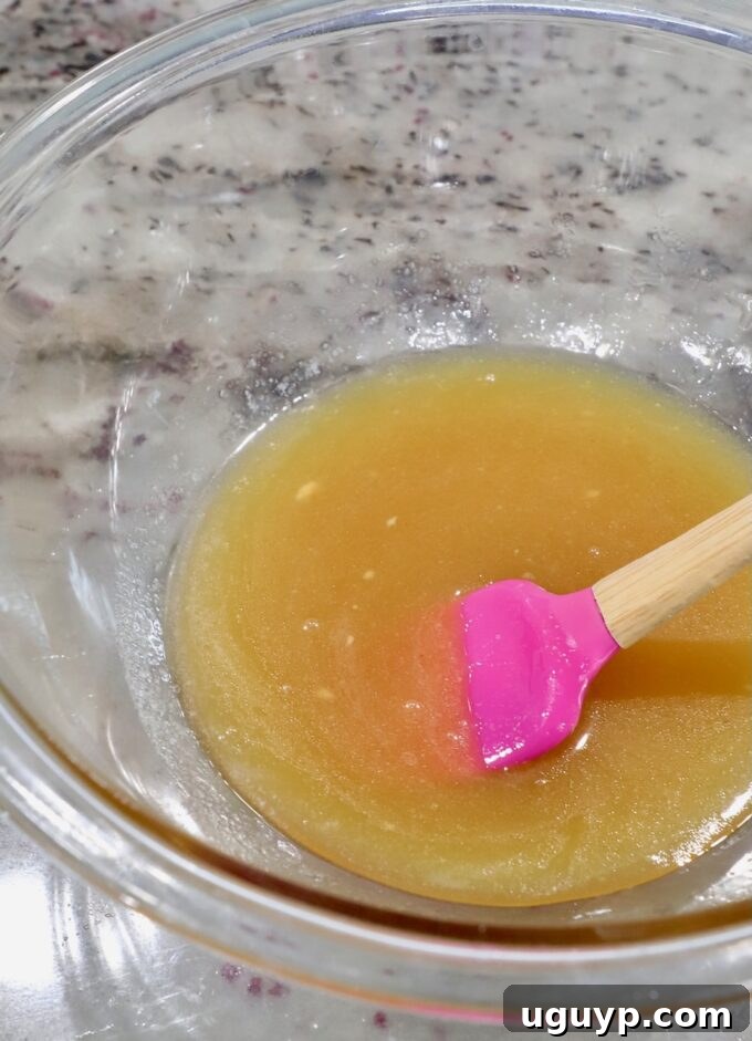 honey glaze mixture in a bowl with a pink spatula