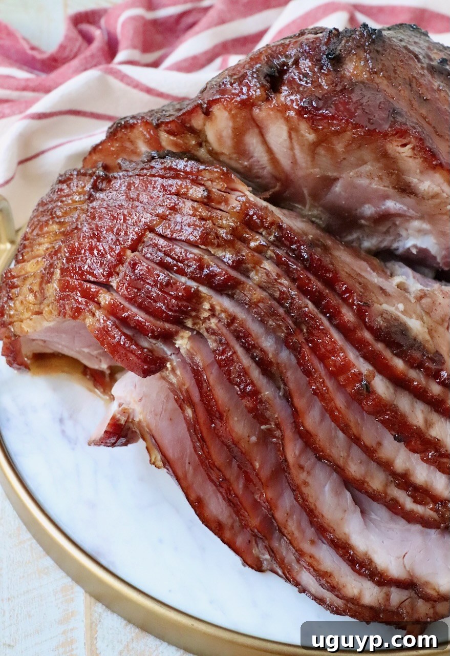 beautifully sliced honey baked ham on a marble serving tray, ready to be enjoyed