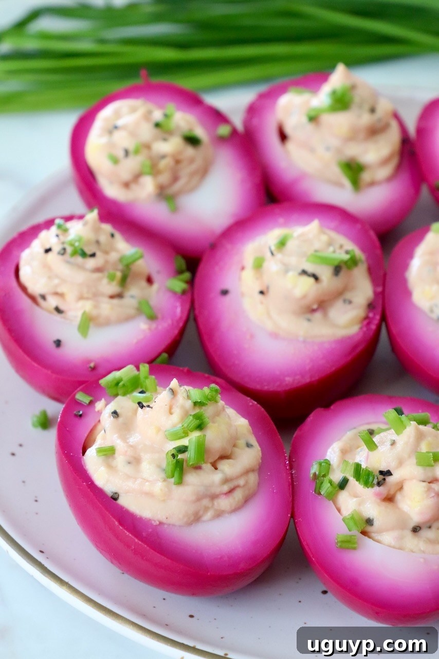Close-up of beet pickled deviled eggs on a plate, showcasing their smooth texture and vibrant pink color