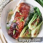 filet of cooked miso glazed salmon in bowl with fork and baby bok choy