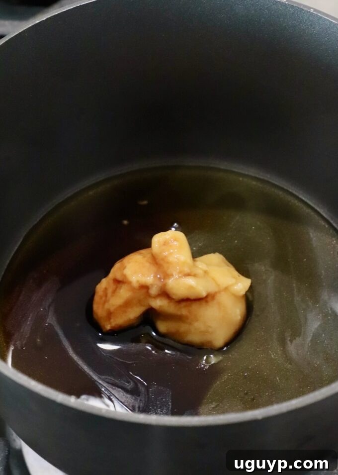 miso paste in a small pot on the stove with sesame oil, honey, mirin and soy sauce