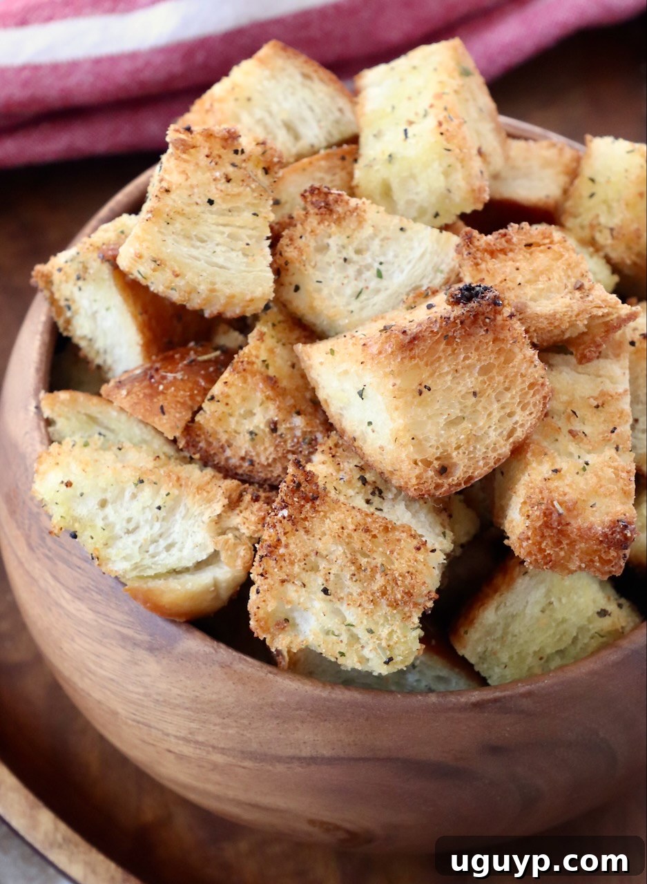 Golden brown homemade croutons in a rustic wooden bowl, ready to enhance any meal.
