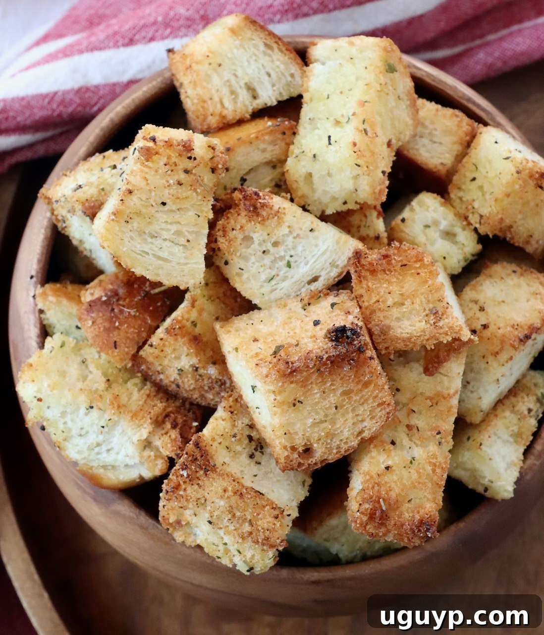 A generous serving of golden homemade croutons in a large wooden bowl, highlighting their crispy texture and inviting appearance.