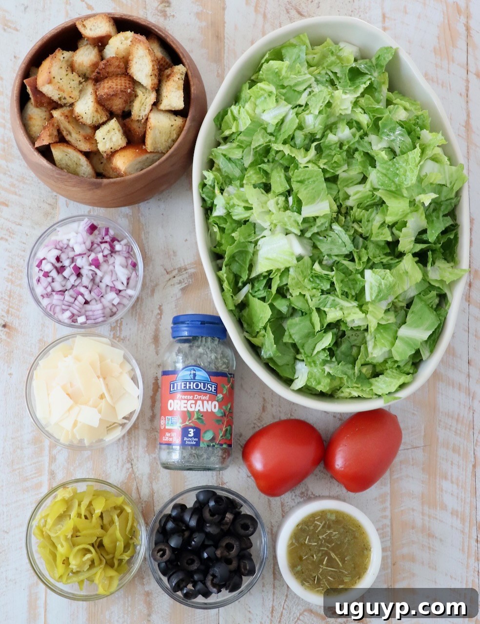 ingredients for Italian salad on white wood board