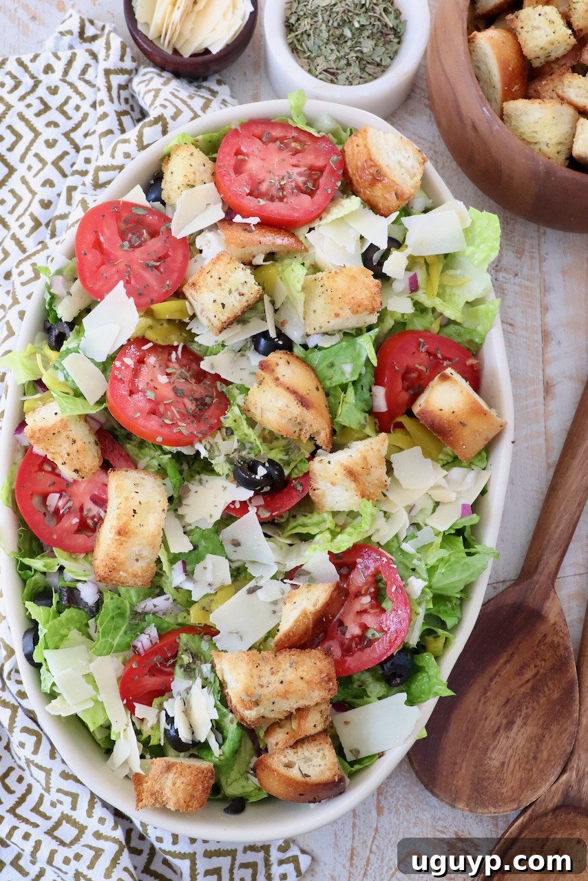salad in serving dish topped with croutons and sliced tomatoes