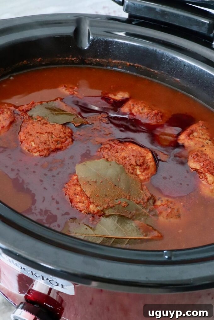cooked chicken thighs in tomato chili broth in slow cooker
