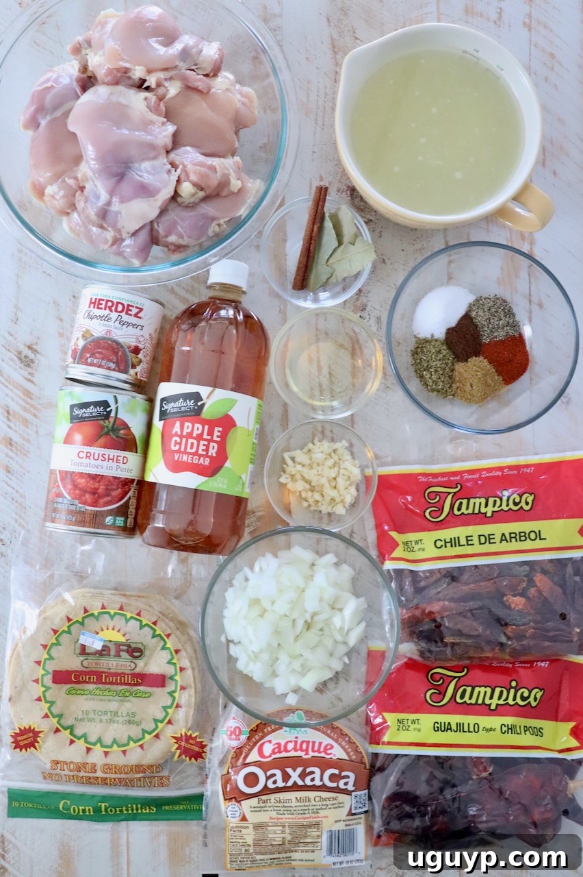 ingredients for chicken birria tacos on white wood board