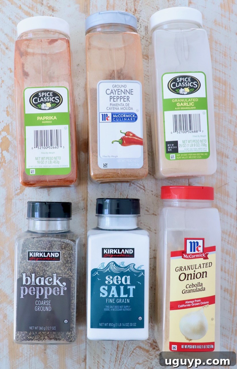 A beautiful display of ingredients for burger seasoning laid out on a white wooden board, highlighting freshness and quality.