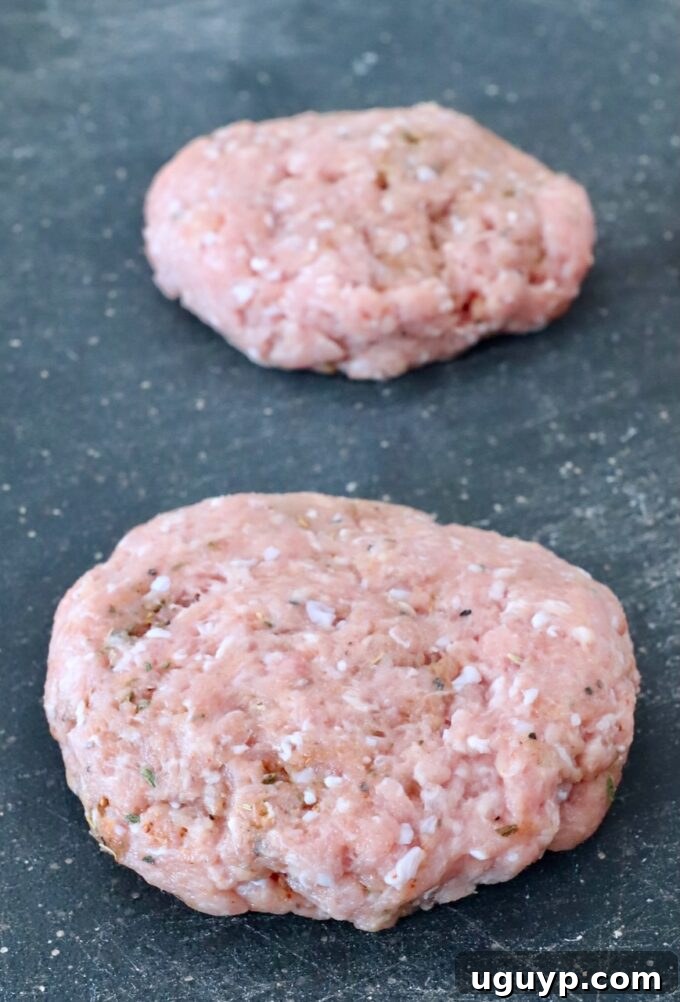 Uncooked turkey burger patties neatly arranged on a cutting board, ready for grilling